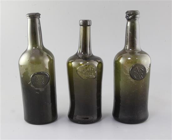Three black glass mallet shaped wine bottles, height 26cm (3)